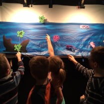Backstage view, moving shadow puppets underwater scene at Digby Elementary